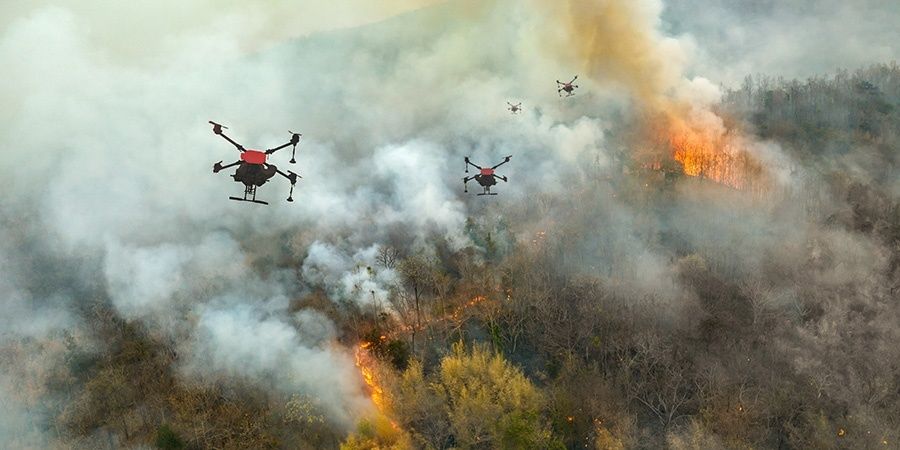 Varios drones sobrevuelan un bosque cubierto de humo y llamas